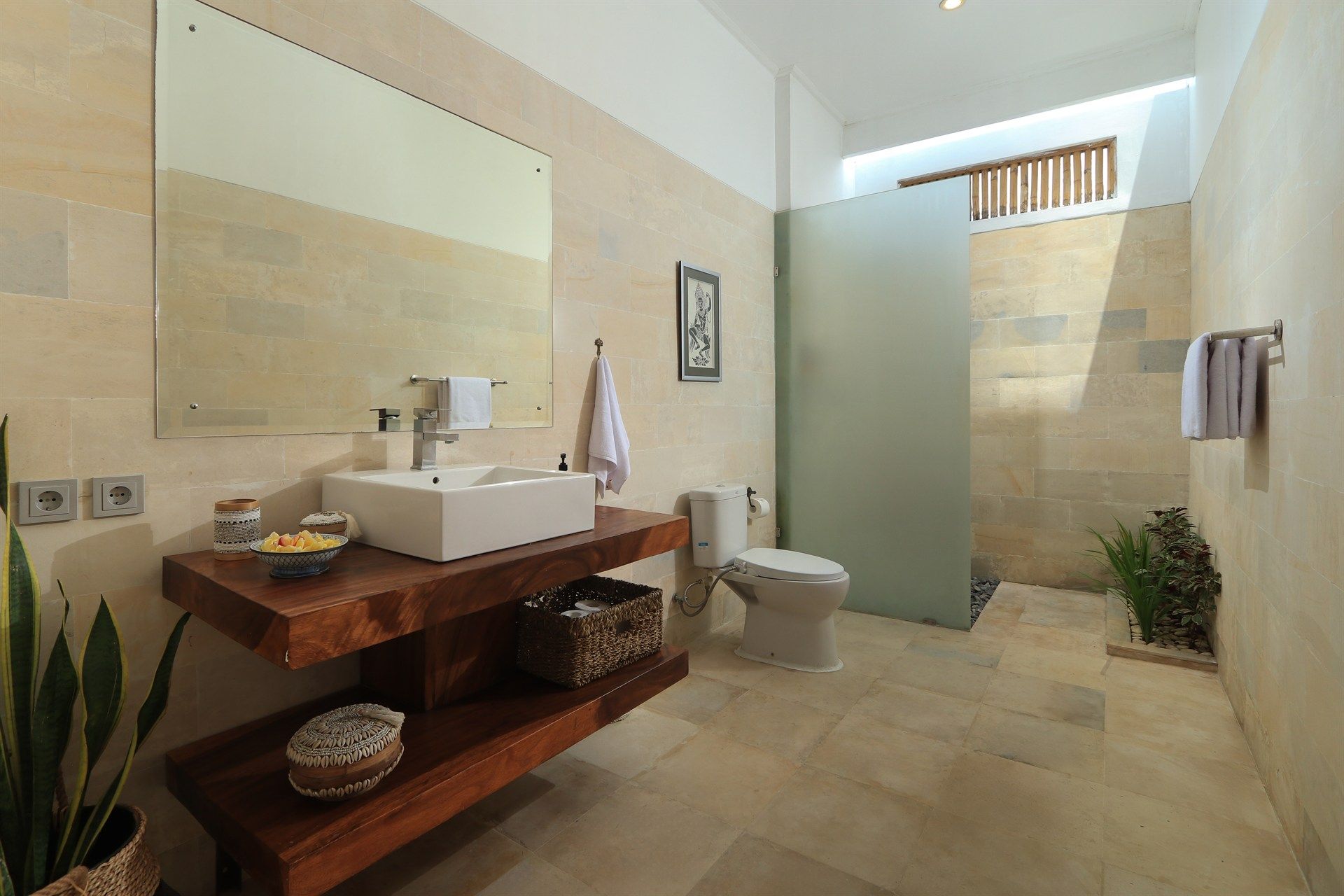 Bathroom with a square sink on a wooden counter, a white toilet, and a frosted glass shower partition.
