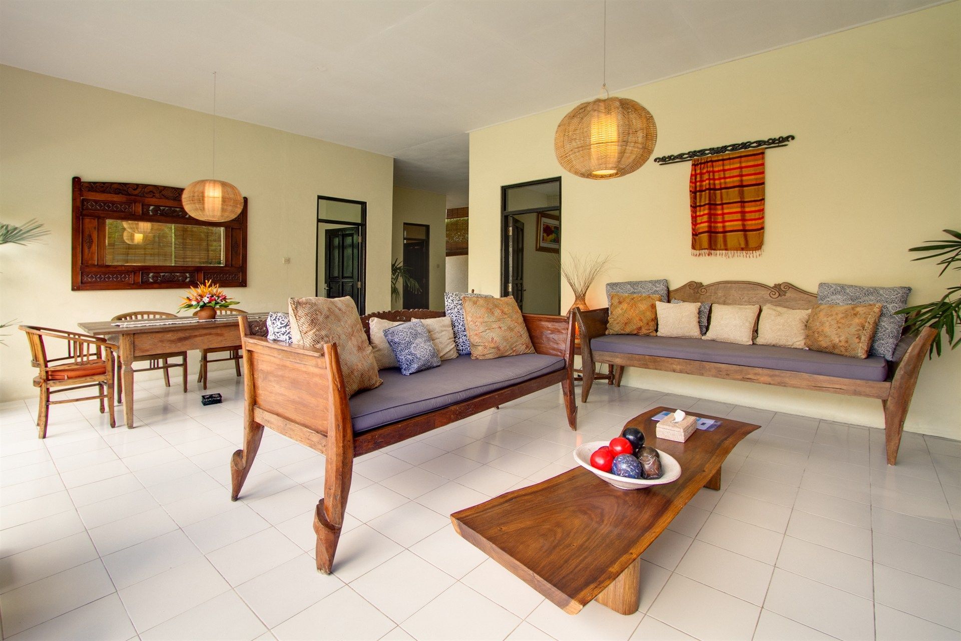 Living room with wooden furniture, including sofas and a coffee table, and pendant lights.