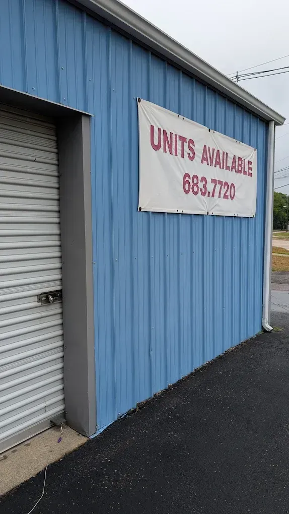A blue metal storage building with a banner that reads 