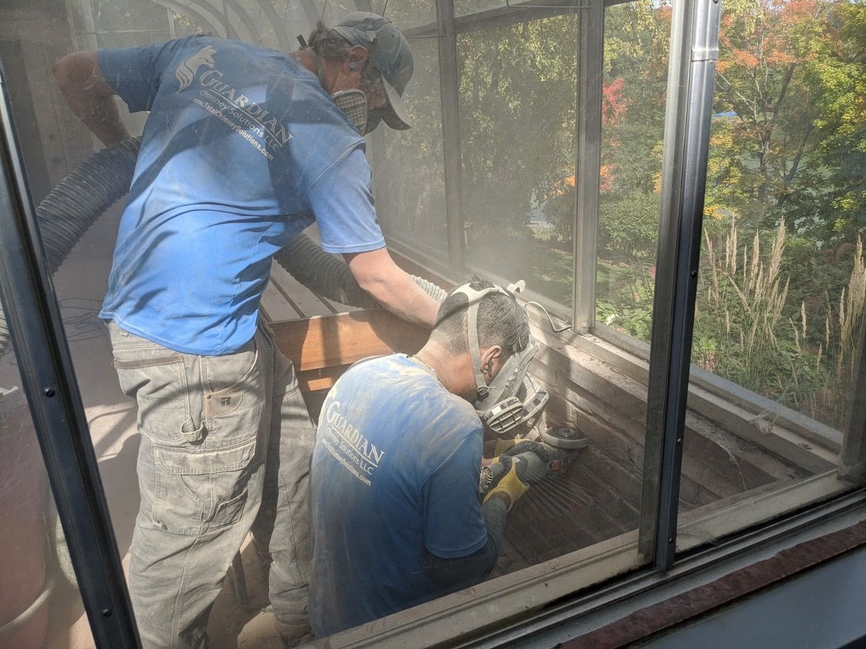 Two men are working on a window sill.