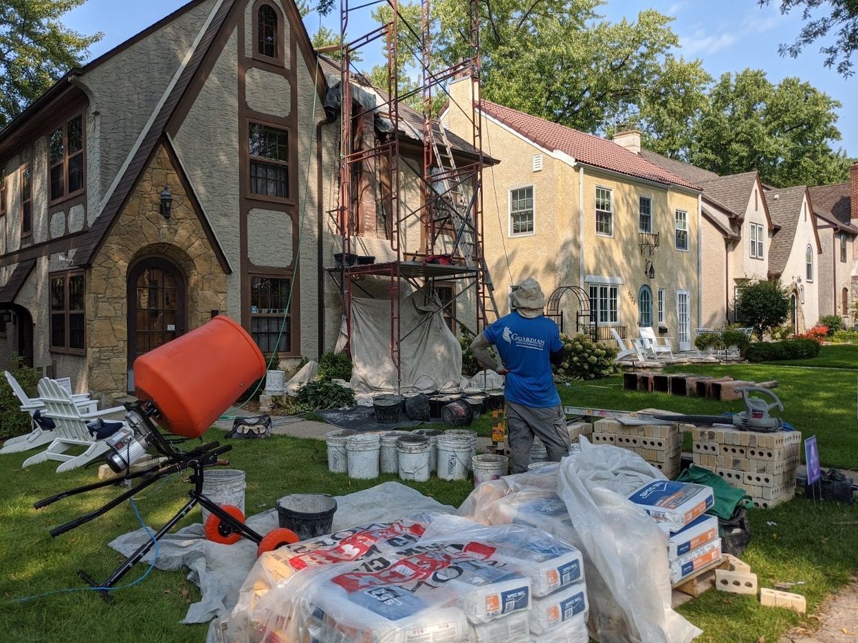 A man is standing in front of a house that is being painted.