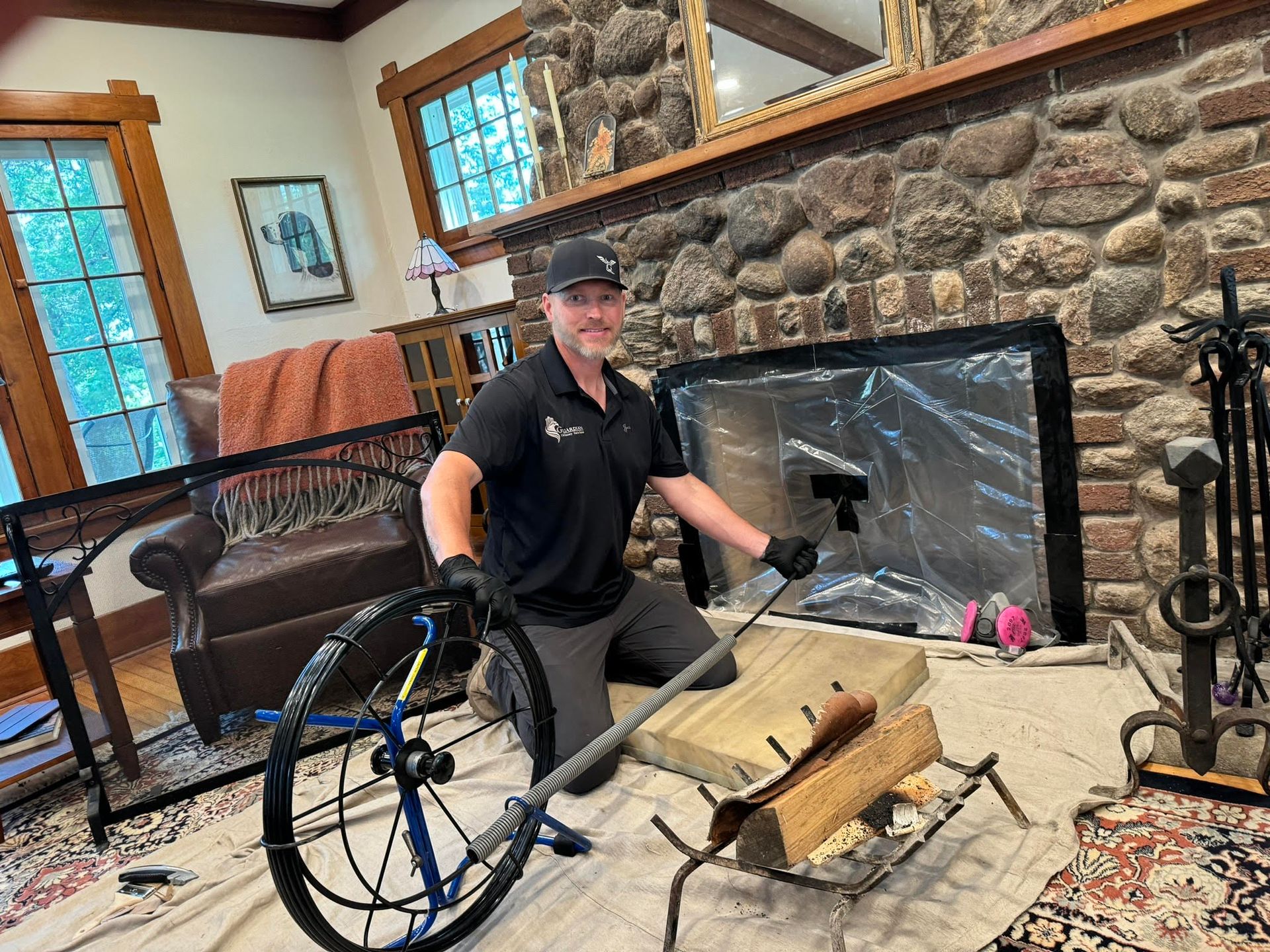 Man kneeling beside a wheelchair in a rustic living room, near a fireplace and tools on the floor
