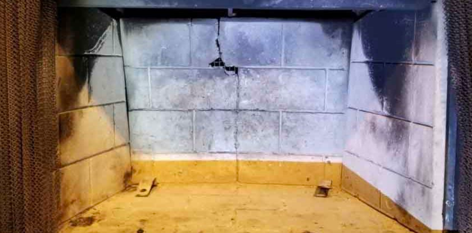 A fireplace with a brick wall and a wooden floor.