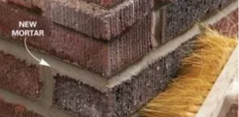 A close up of a brick wall with a brush on it.