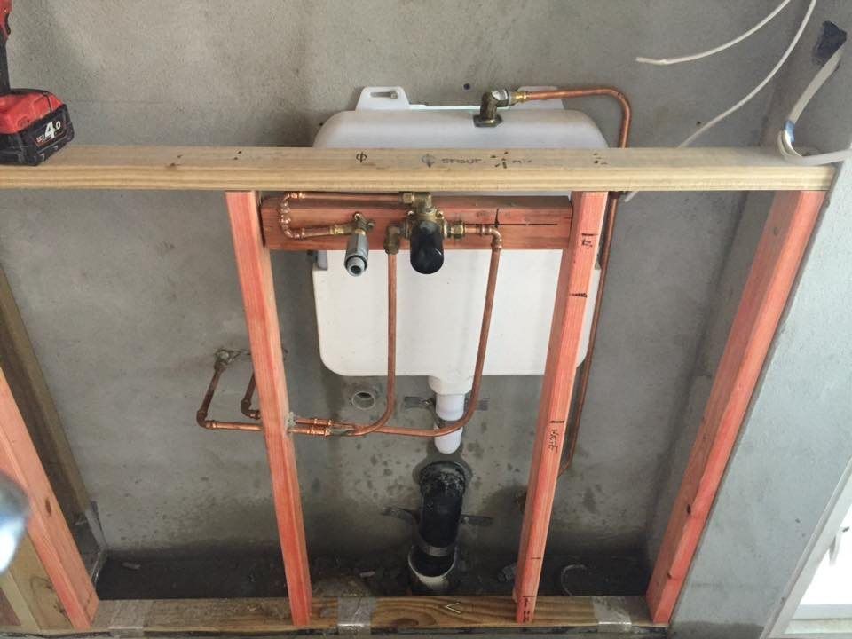 A Bathroom Sink is Being Built With Copper Pipes and a Drill — Reed Plumbing Industries in Mackay, QLD