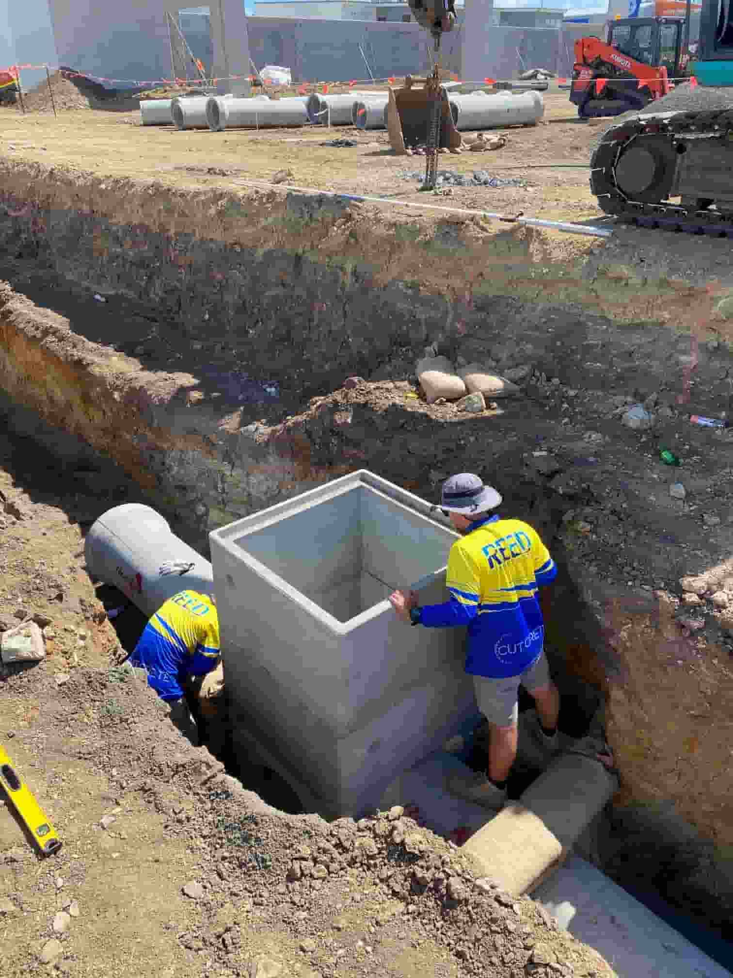 A Group of Construction Workers Are Working on a Construction Site — Reed Plumbing Industries in Airlie Beach, QLD