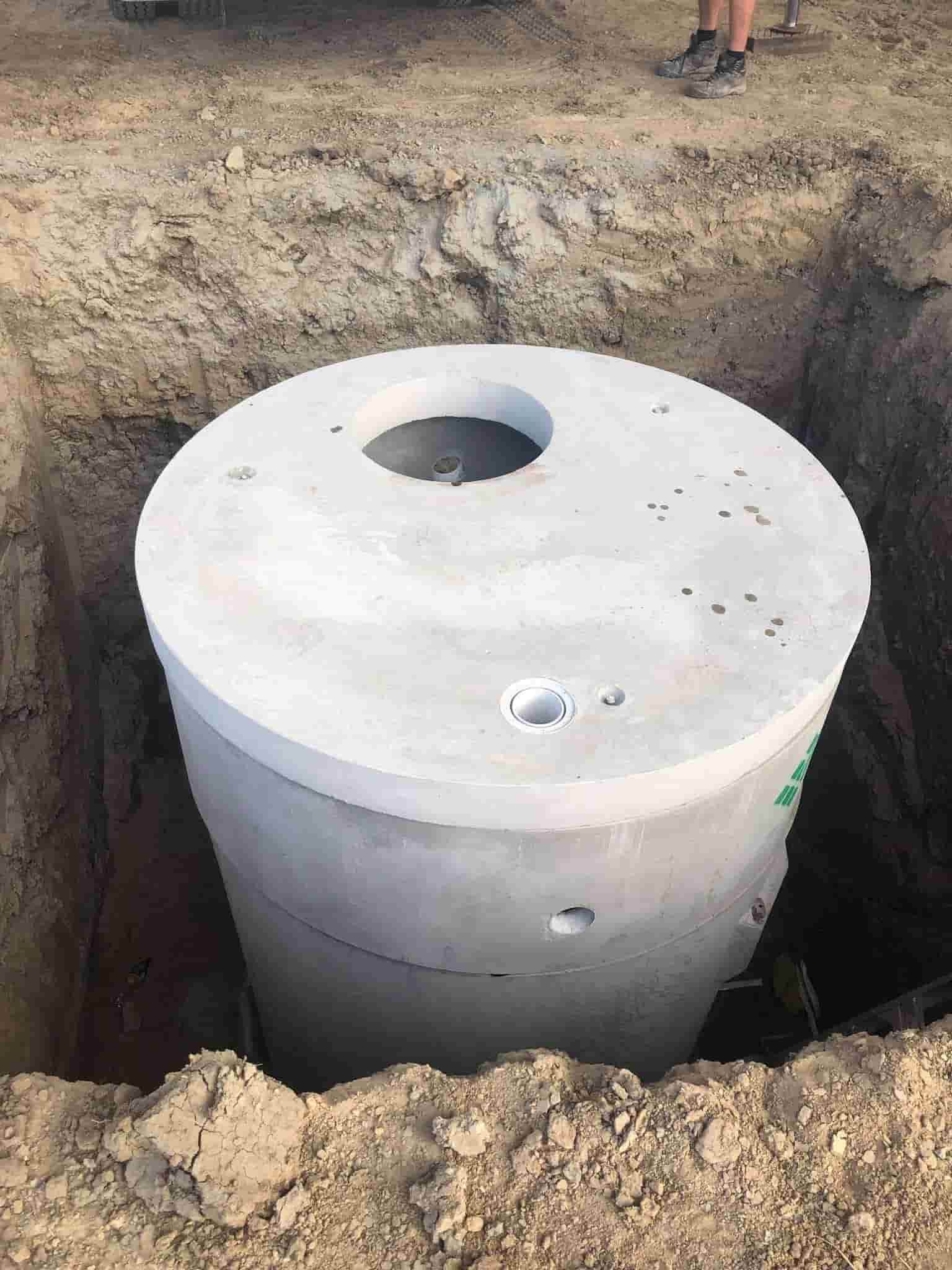 A Large Concrete Septic Tank is Sitting in a Hole in the Ground — Reed Plumbing Industries in Andergrove, QLD
