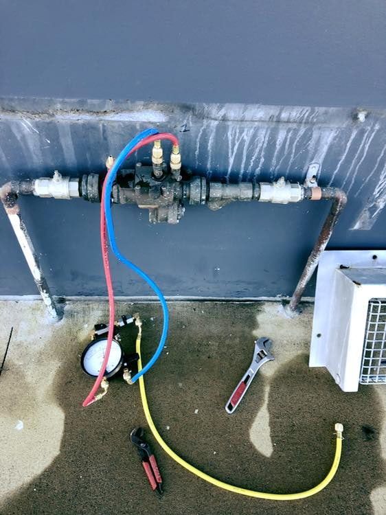 A Wrench is Laying on the Ground Next to a Hose — Reed Plumbing Industries in Andergrove, QLD