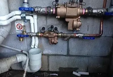 A Bunch of Pipes Are Connected to a Wall — Reed Plumbing Industries in Andergrove, QLD