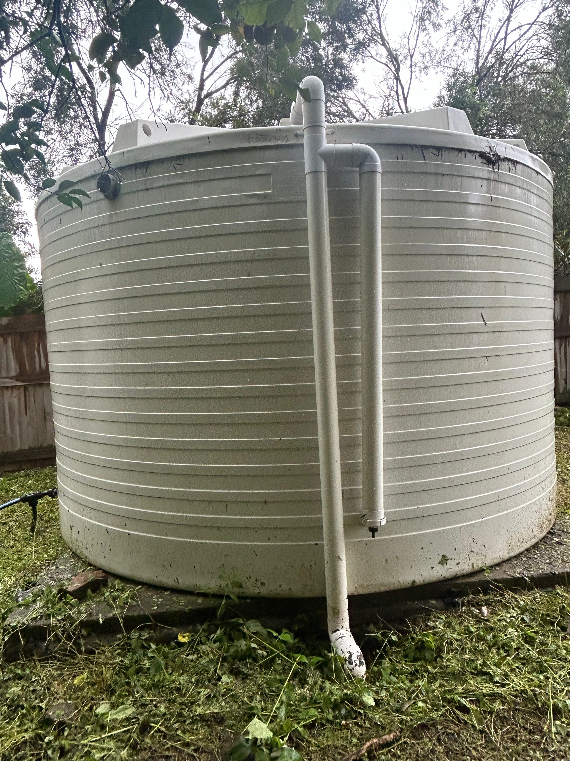 A Large Septic Tank is Sitting on a Slab of Concrete in a Grassed area — Reed Plumbing Industries in Mackay, QLD
