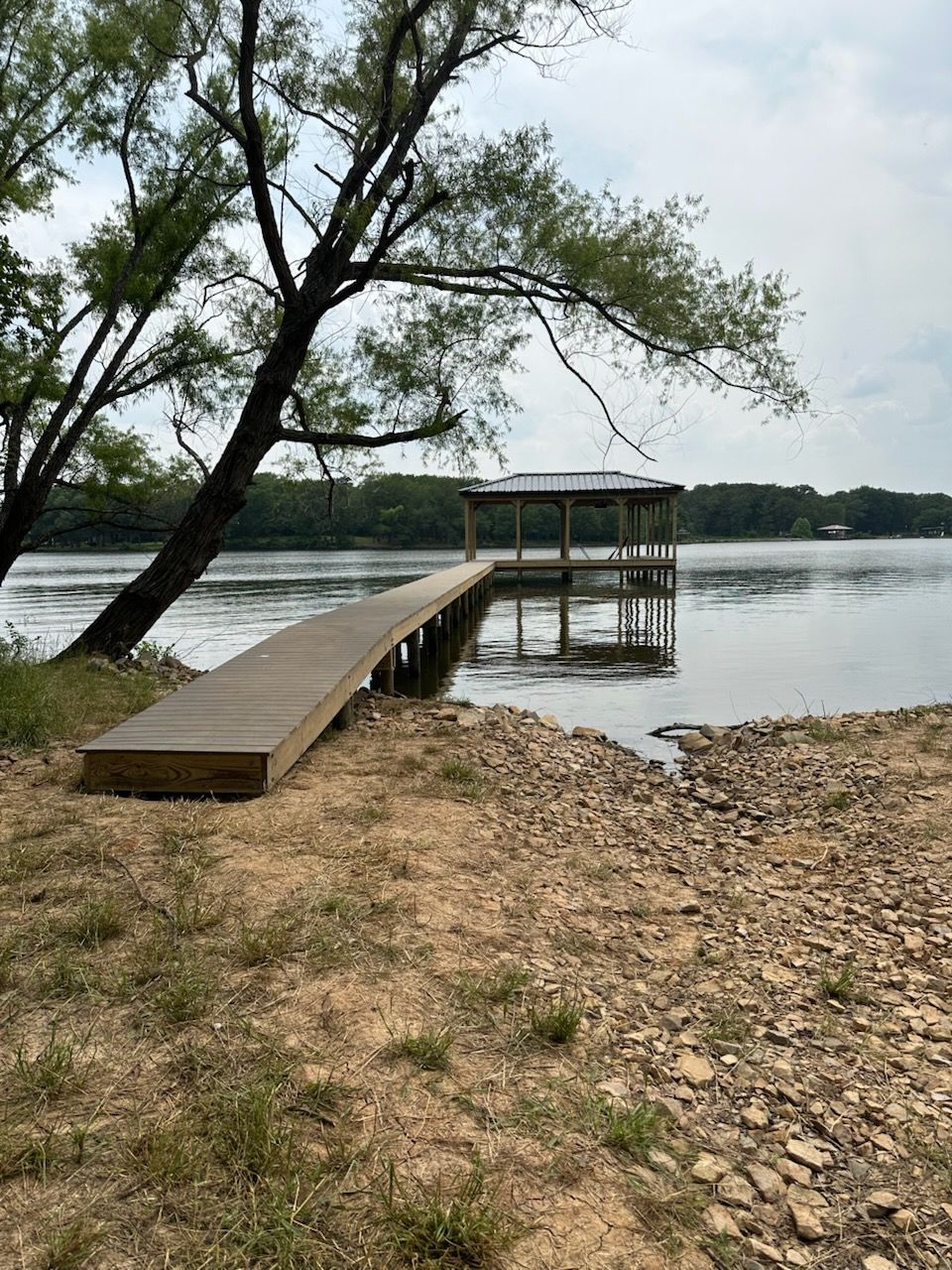 A wooden dock is sitting on the shore of a lake.