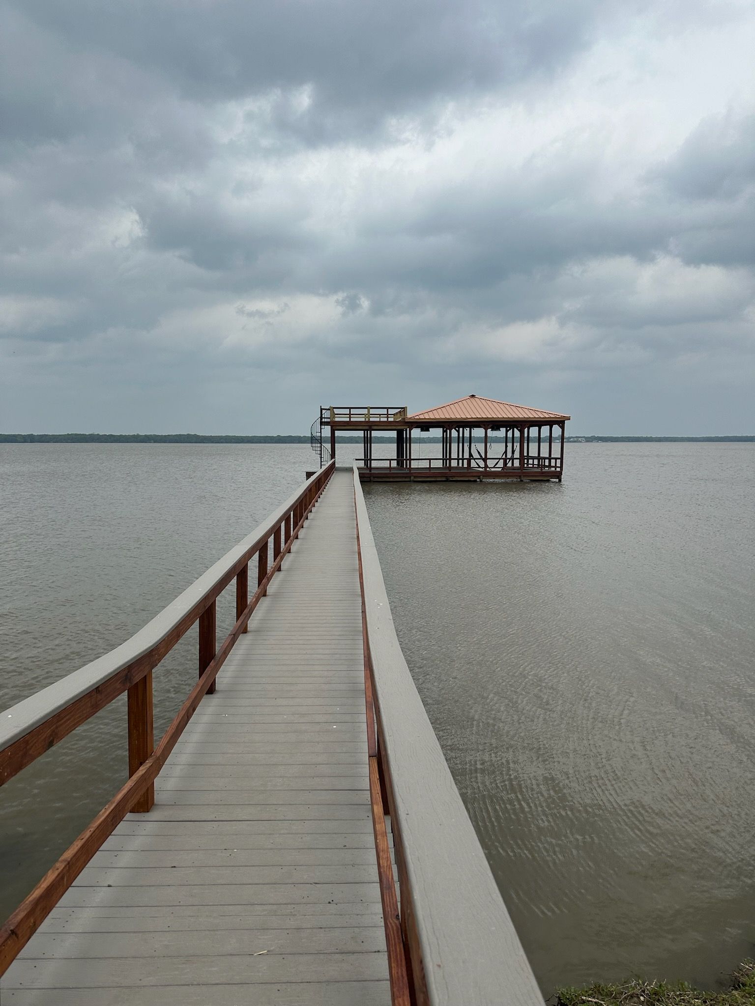A wooden dock leading to a house in the middle of a body of water