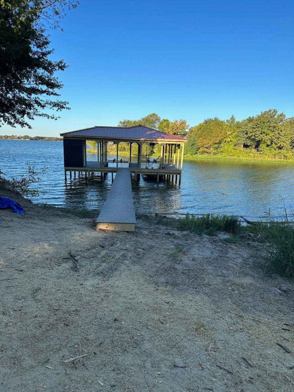 A dock is sitting on the shore of a lake.