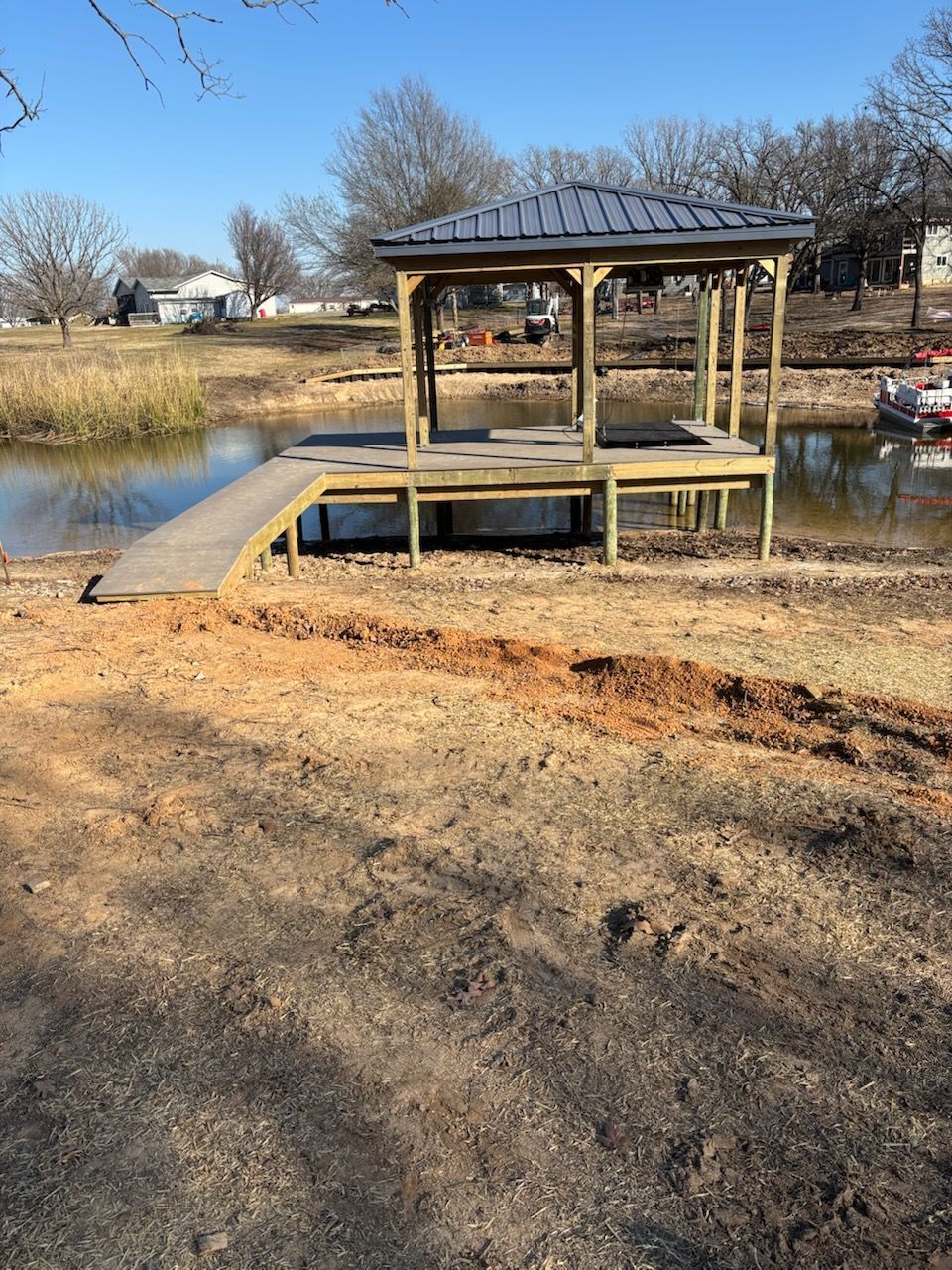 A wooden dock is sitting next to a body of water.