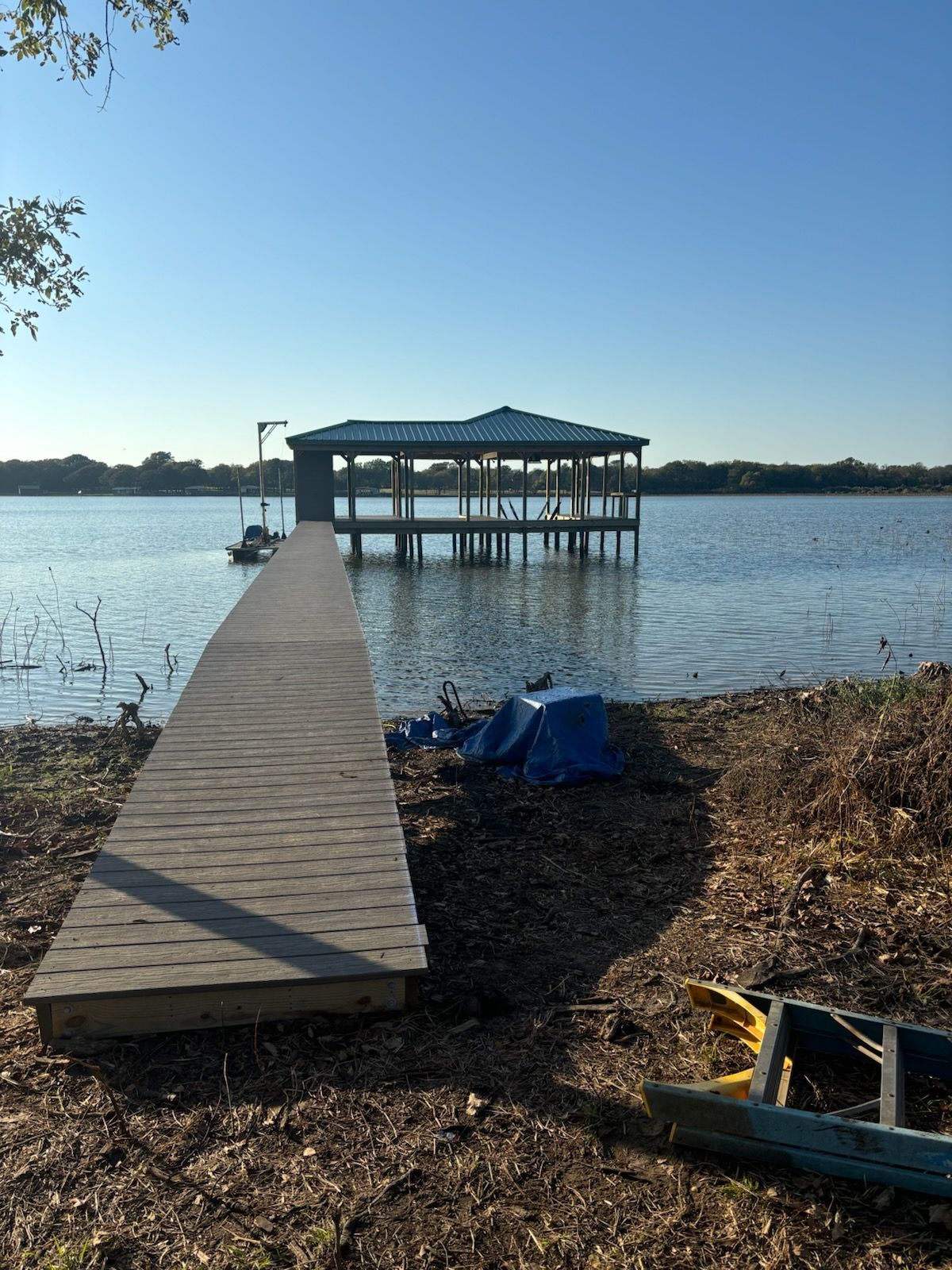 A wooden dock is sitting on the shore of a lake.