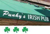 A green awning for punky 's irish pub with three shamrocks on it.