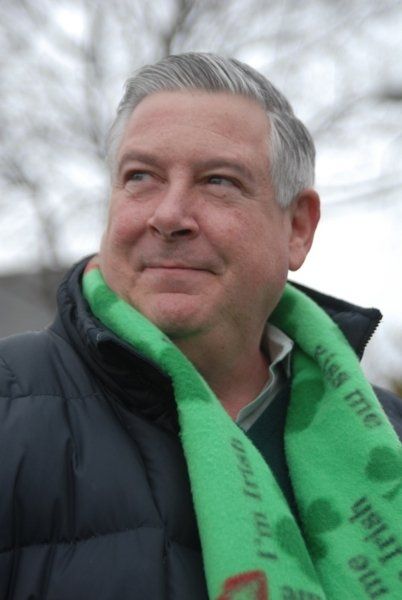 A man wearing a green scarf that says i 'm all irish