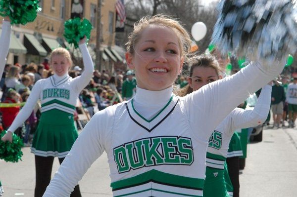 Cheerleaders wearing green and white uniforms with the word dukes on them