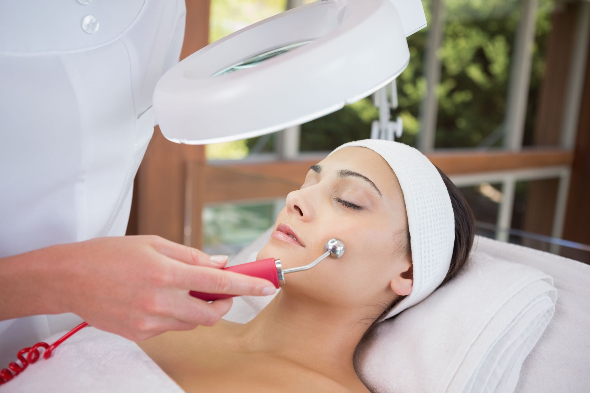 Peaceful brunette getting micro dermabrasion from beauty therapy.