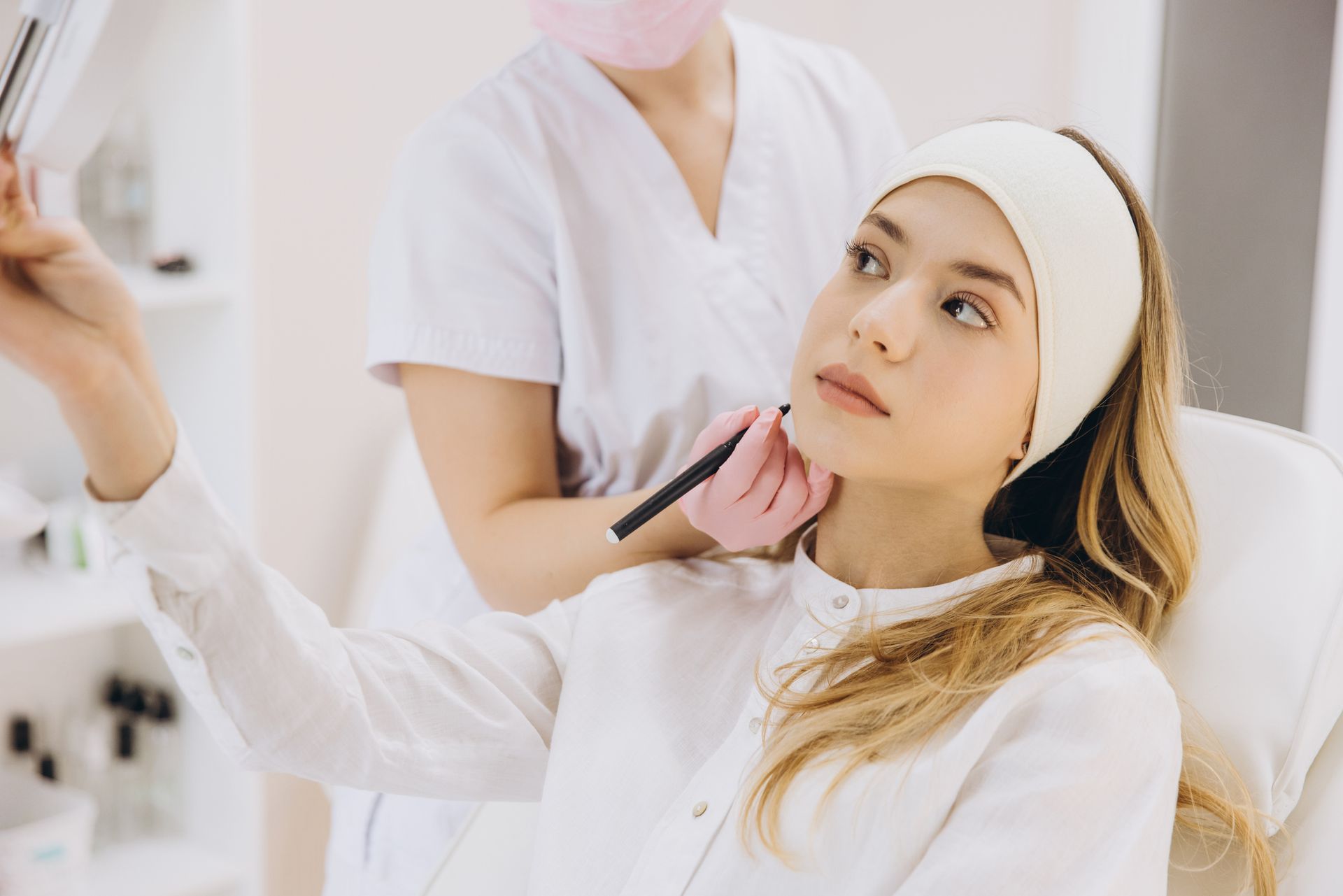 Person in a beauty clinic receiving a cosmetic procedure from a professional. Person in a beauty clinic receiving a cosmetic procedure from a professional.