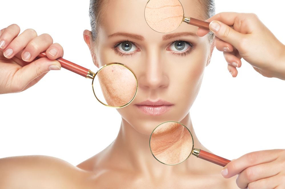 Woman's face with magnifying glasses highlighting wrinkles on forehead, cheek, and neck.