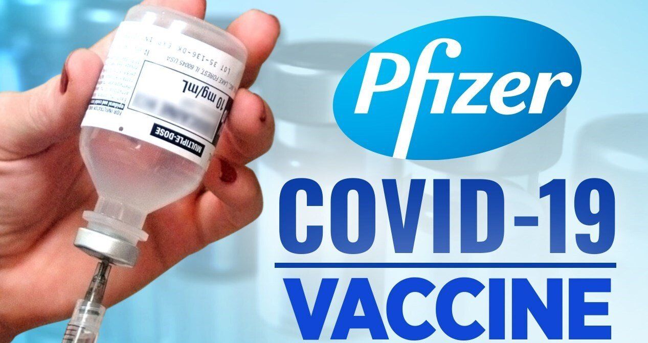 Pfizer COVID-19 vaccine vial being filled with a syringe. Blue Pfizer logo in the background.