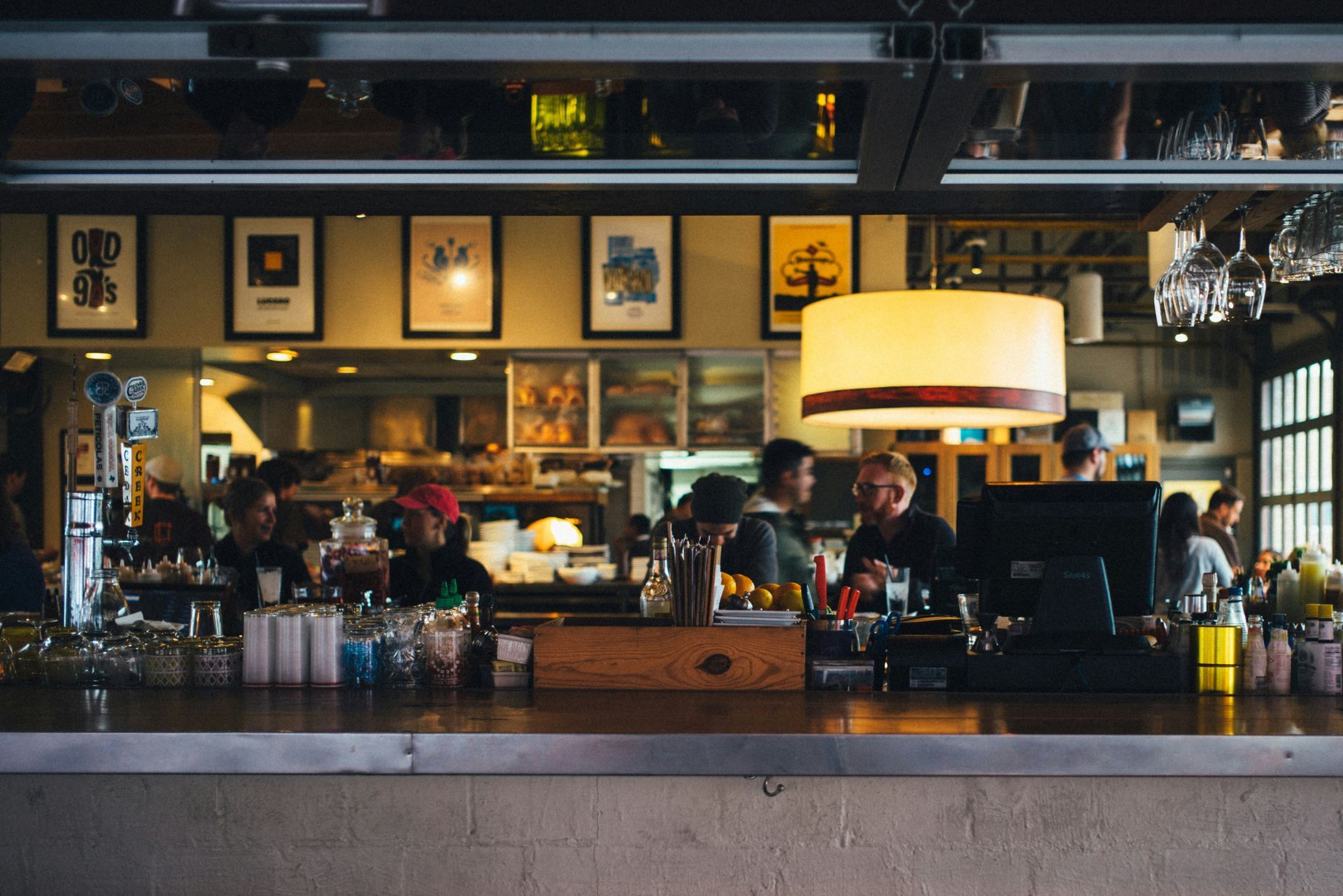 a group of people are sitting at a bar in a restaurant .