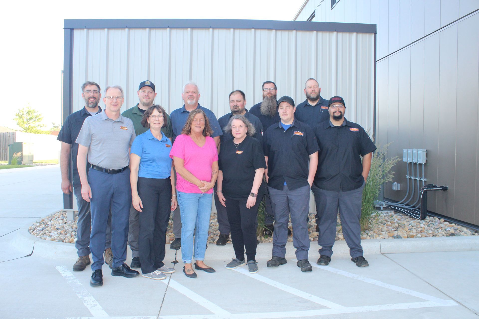 Group of coworkers standing outside an industrial building in bright sunlight