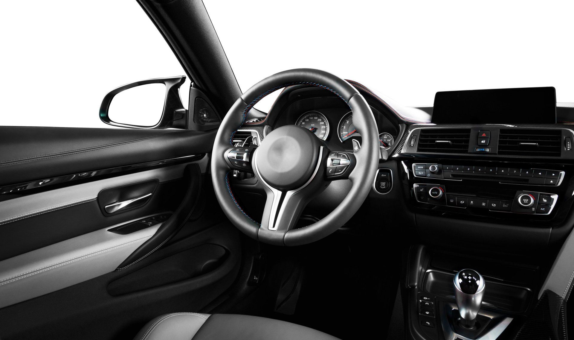 Interior of a modern car, showing the steering wheel, dashboard, and center console in black and silver.