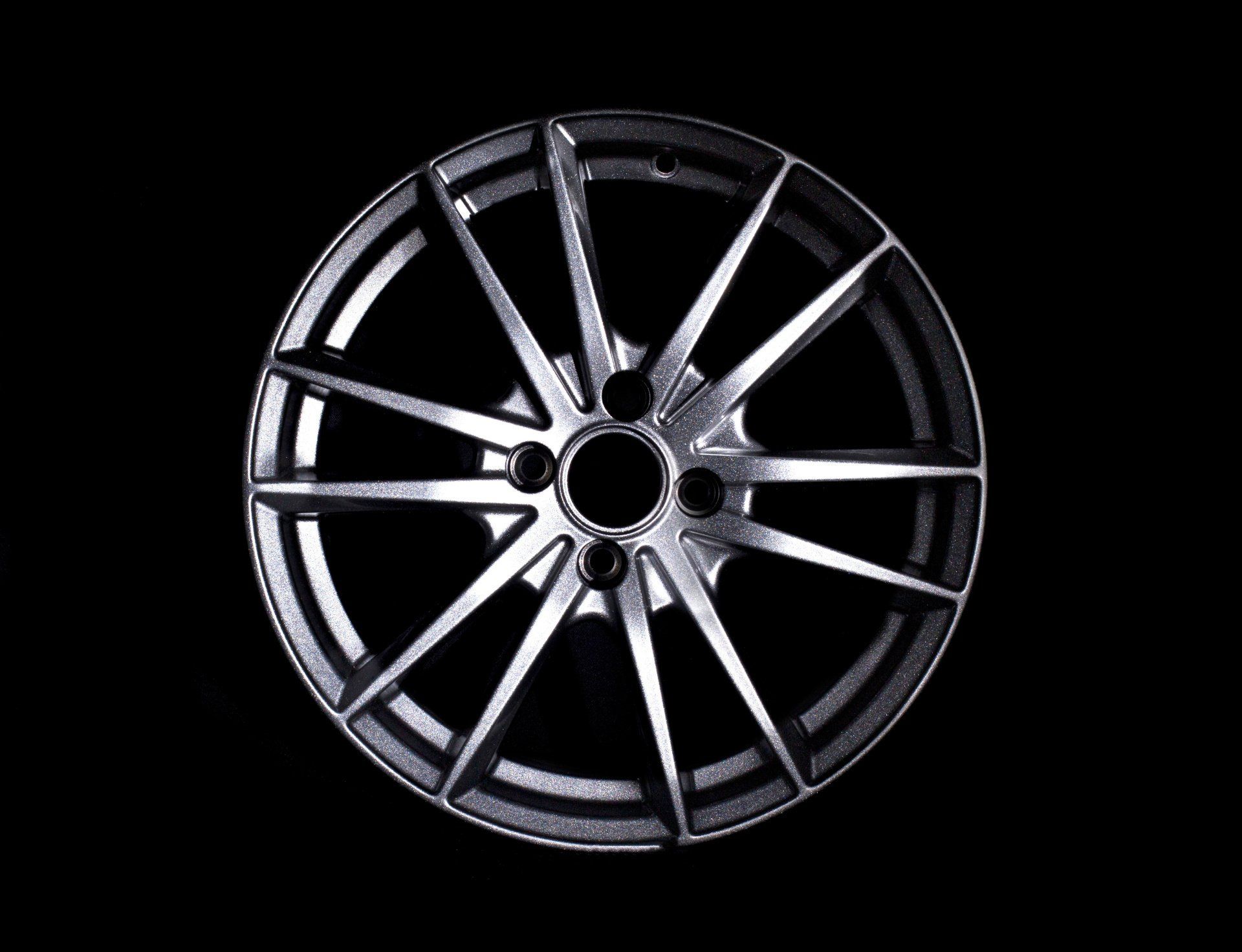 Silver multi-spoke alloy wheel rim on a black background