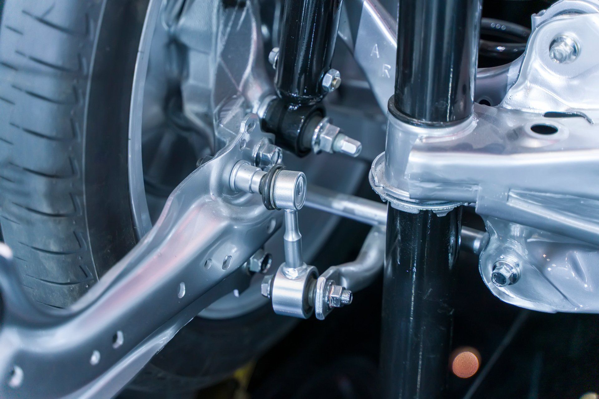 Close-up of a car’s suspension and steering linkage with chrome and black components