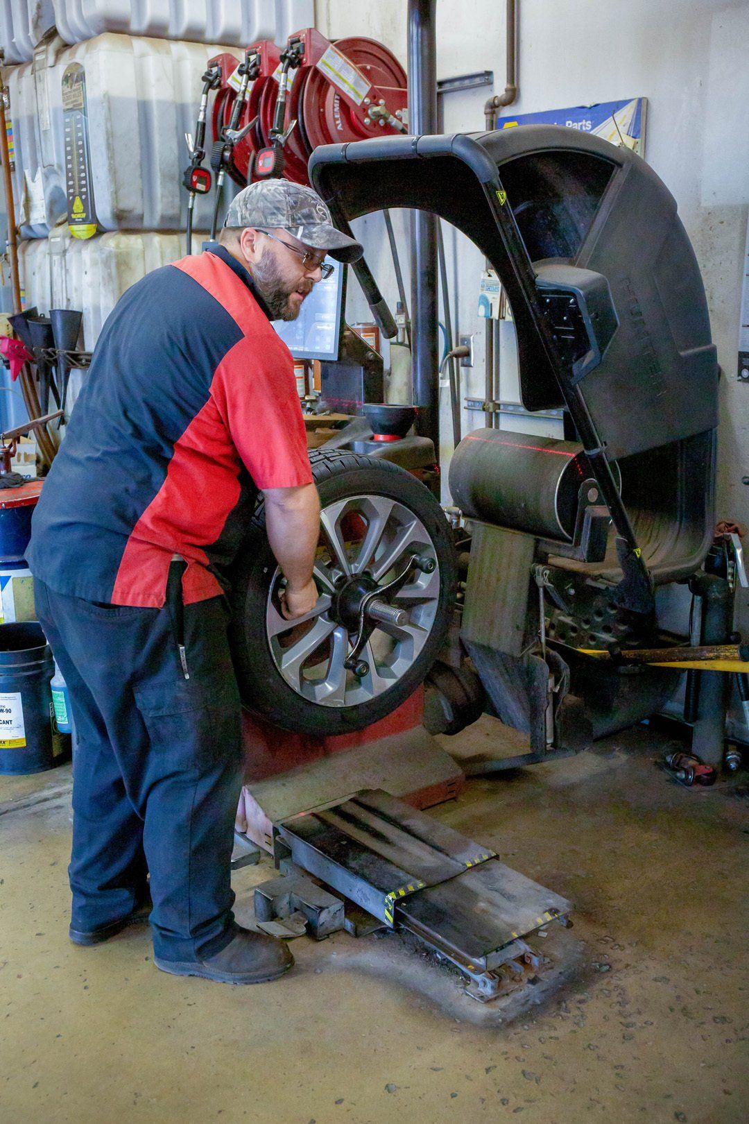 Mechanic using a tire balancer in an auto repair shop