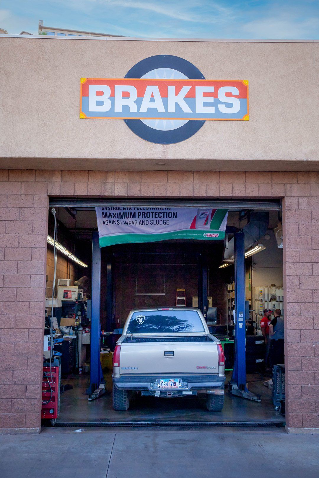 Auto repair shop with a red-and-white BRakes sign and a car inside the open garage bay