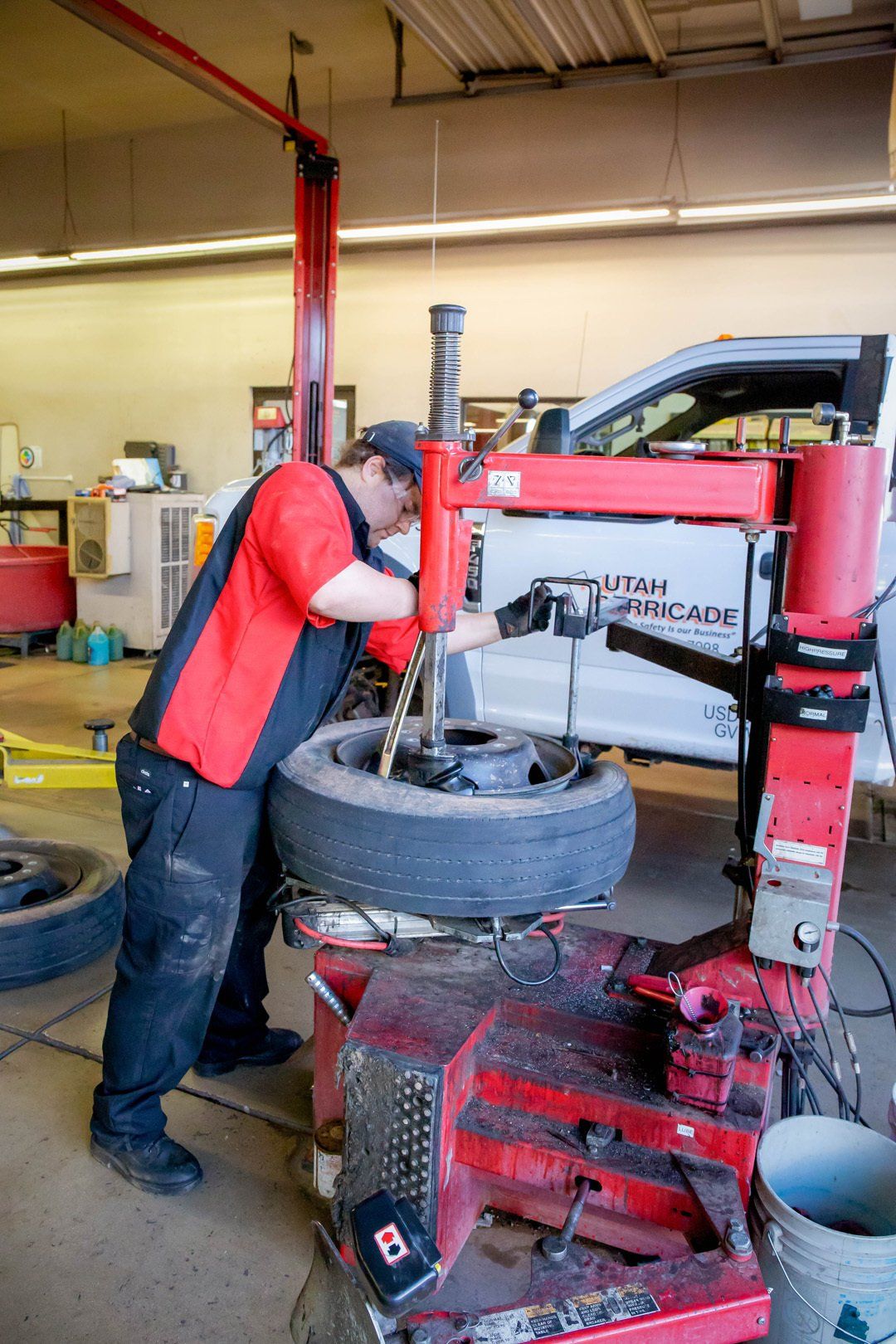 Mechanic using a tire changer to remove a tire in an auto repair shop