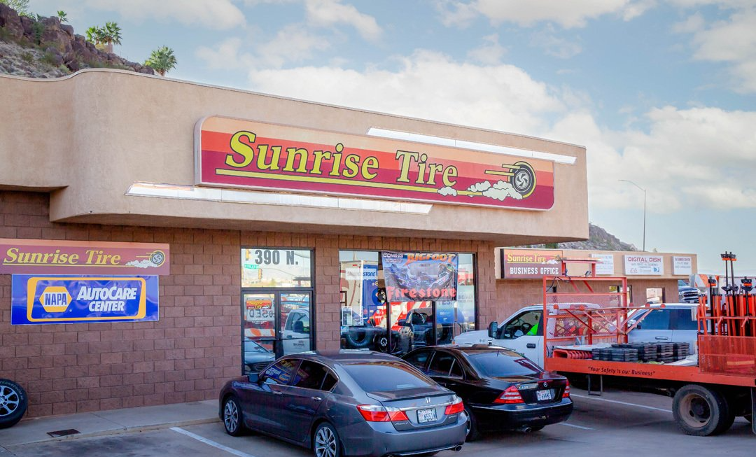 Sunrise Pizza storefront with parked cars and a red truck in front