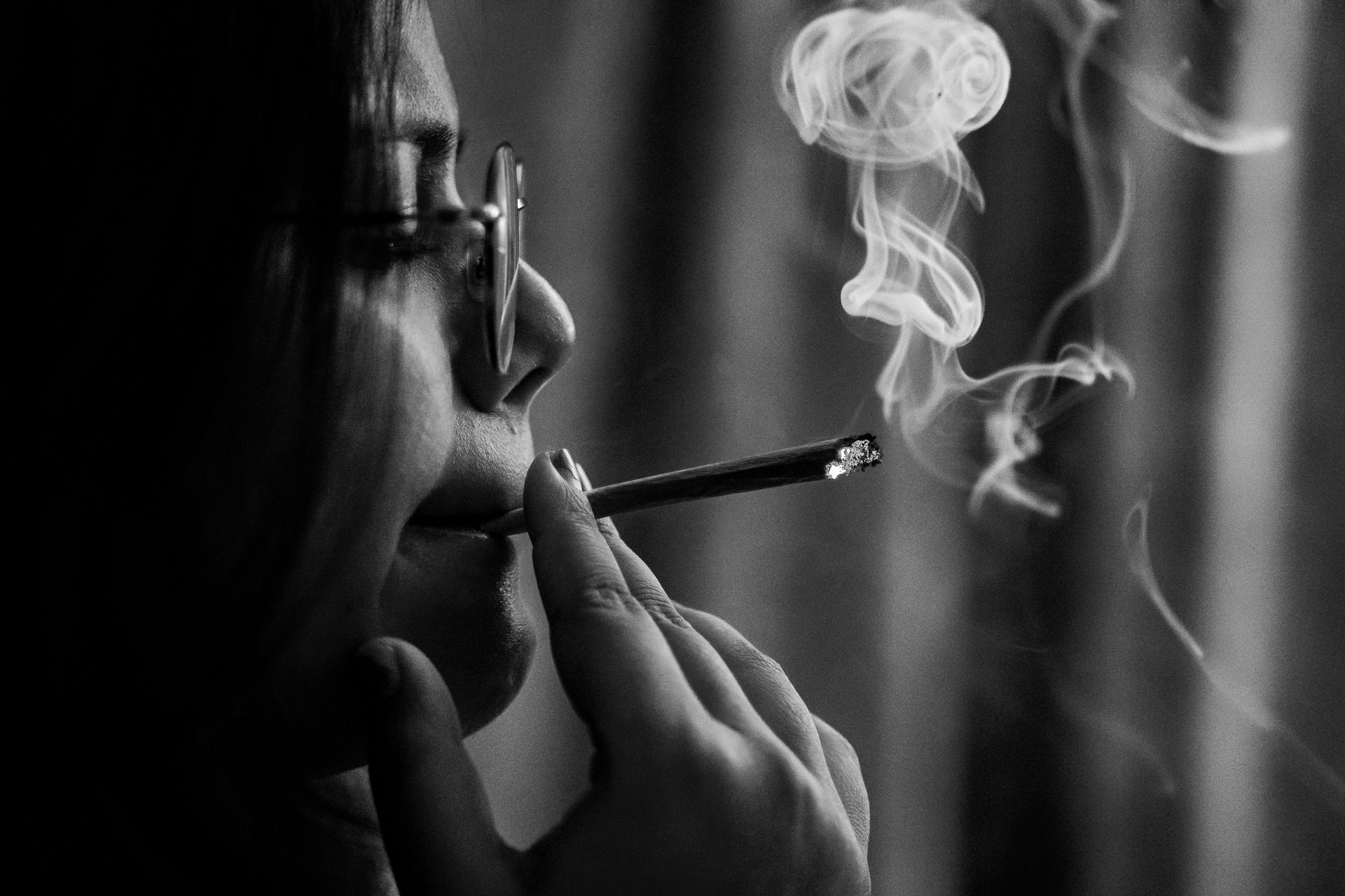 Person smoking a cigarette, smoke rising.