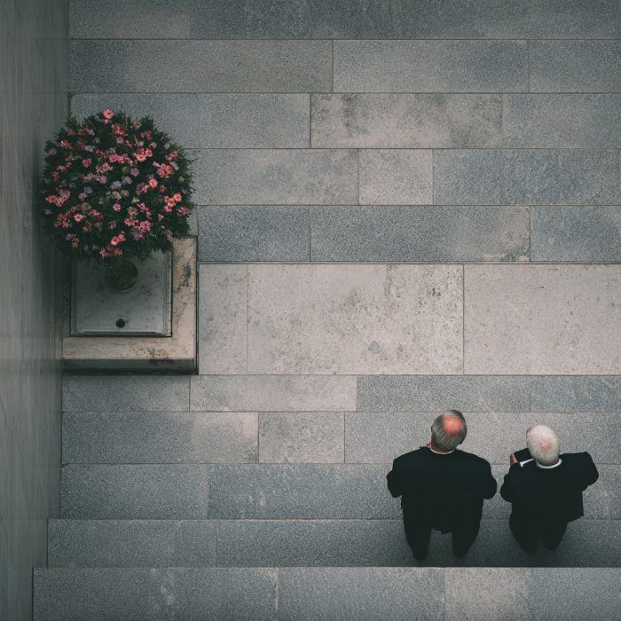 Funeral Services in Red Lion, PA shows two men in suits standing on a stone memorial walkway beside pink flowers