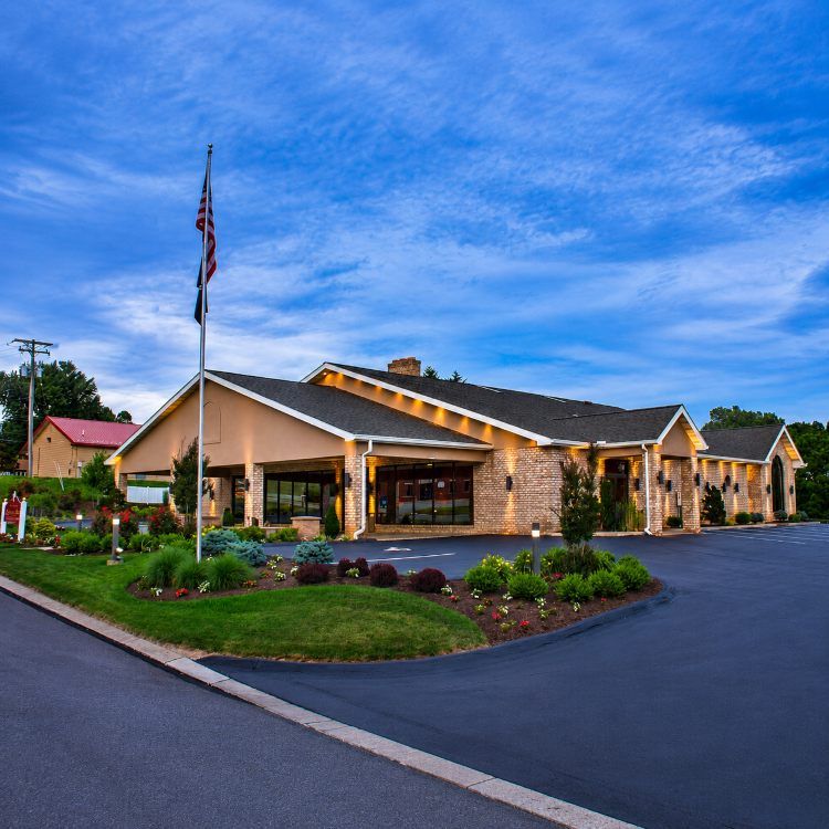 Heffner Funeral Chapel & Crematory, Inc. exterior at dusk with landscaped grounds, flag, and modern brick building