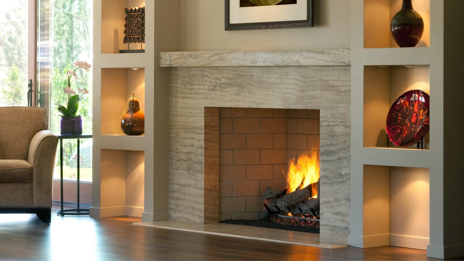 Modern living room fireplace with built-in shelves, glowing fire, and decorative vases and art.
