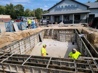 A swimming pool is being built in front of a building.