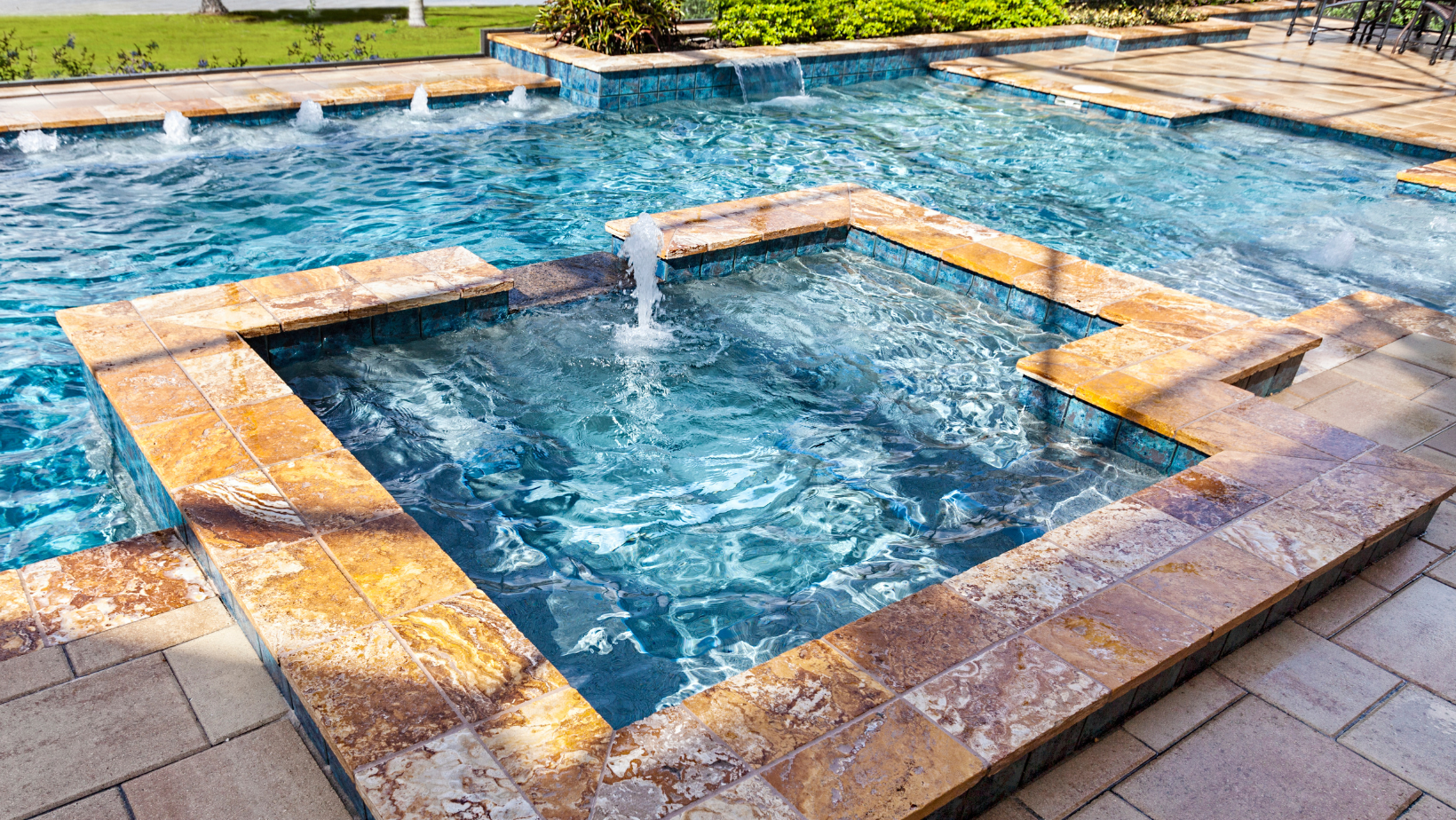 A large swimming pool with a hot tub in the middle of it.