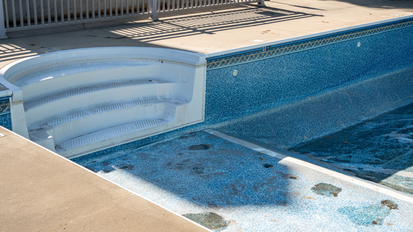 A swimming pool with blue tiles and white steps.
