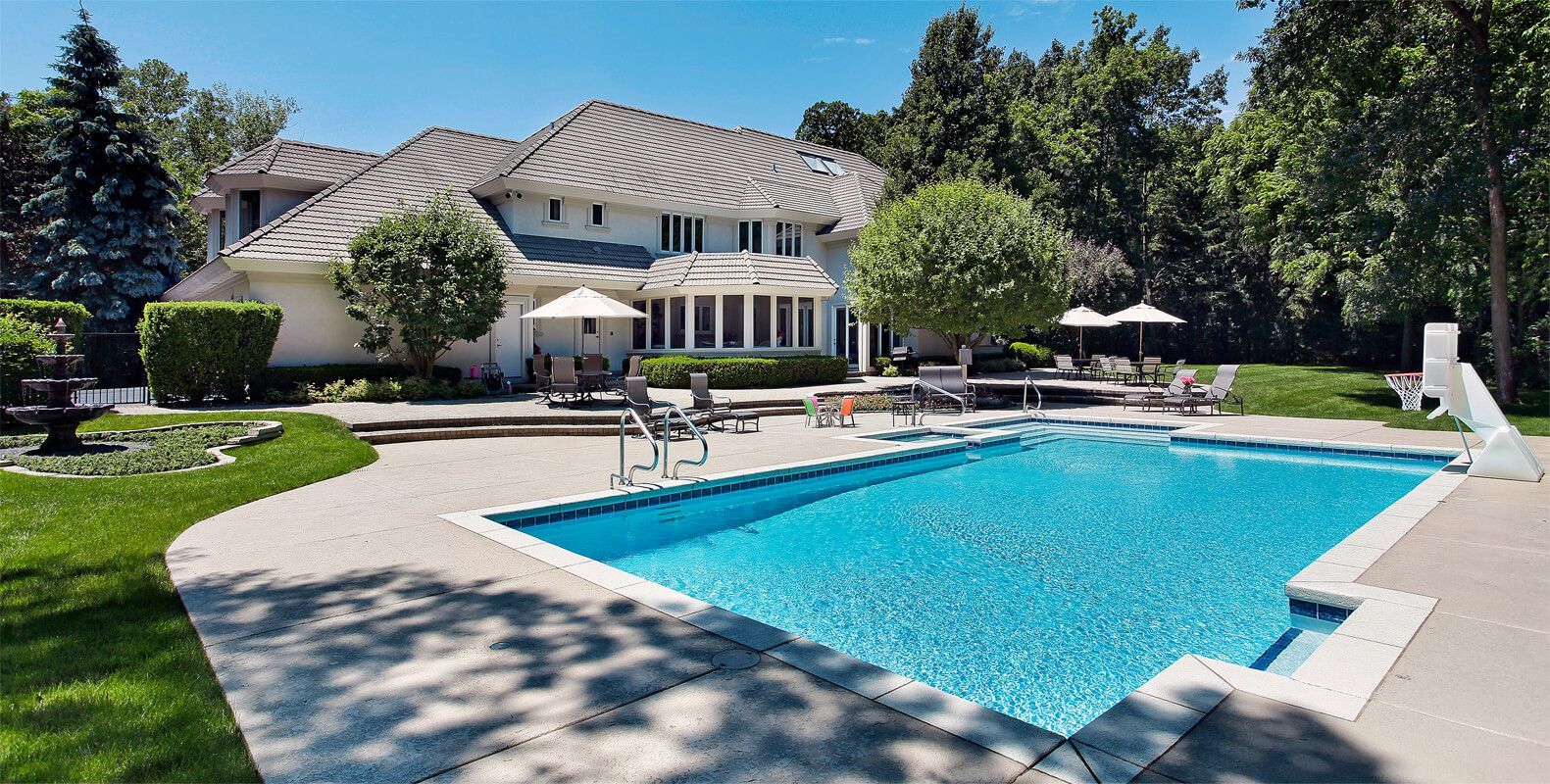 A large house with a large swimming pool in front of it.