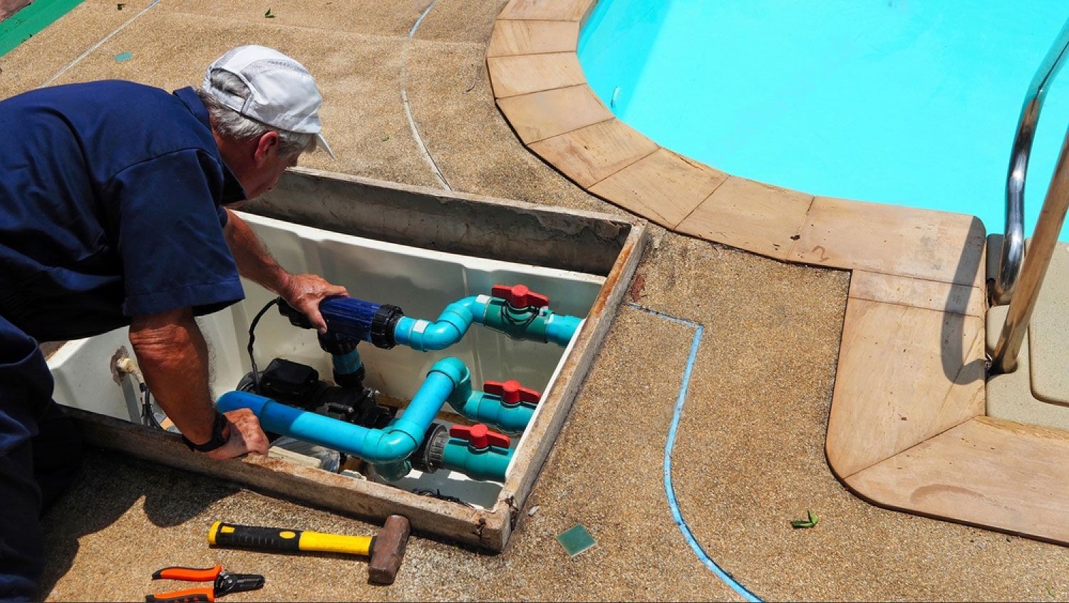 A man is working on a swimming pool pump.