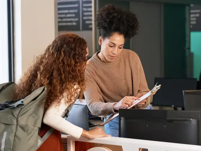 Woman helping a young girl with school registration
