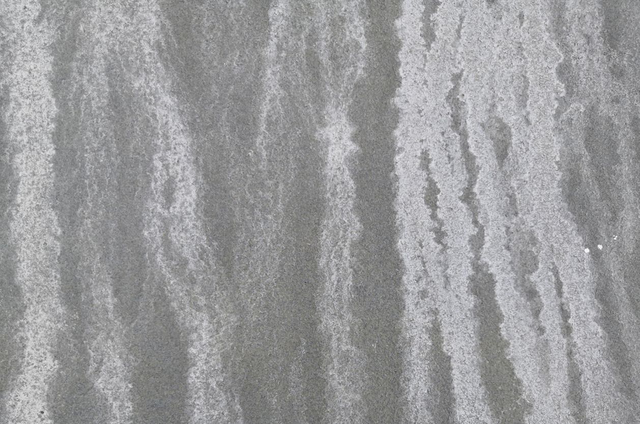 a close up of a gray surface with a grainy texture from water stains