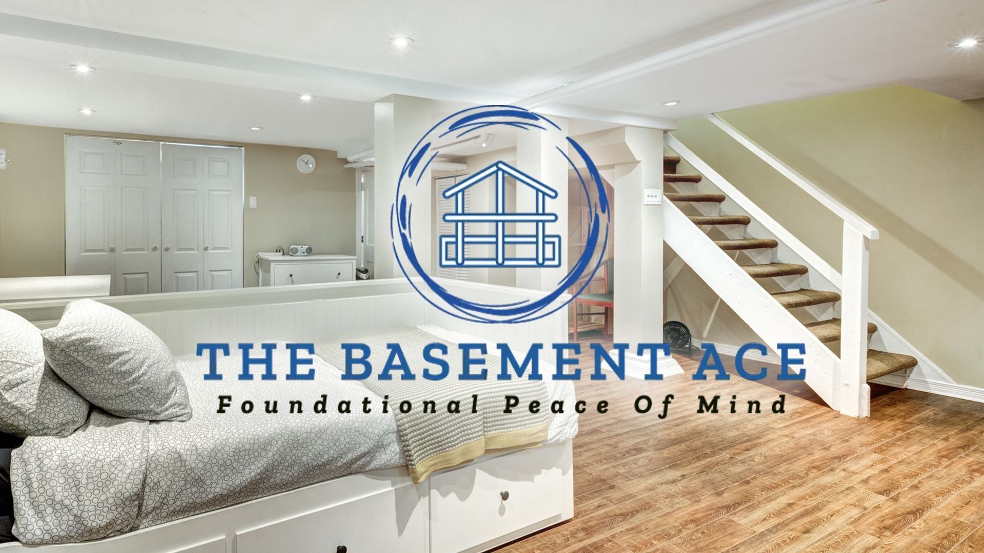 A basement with a bed , stairs and a logo for the basement ace