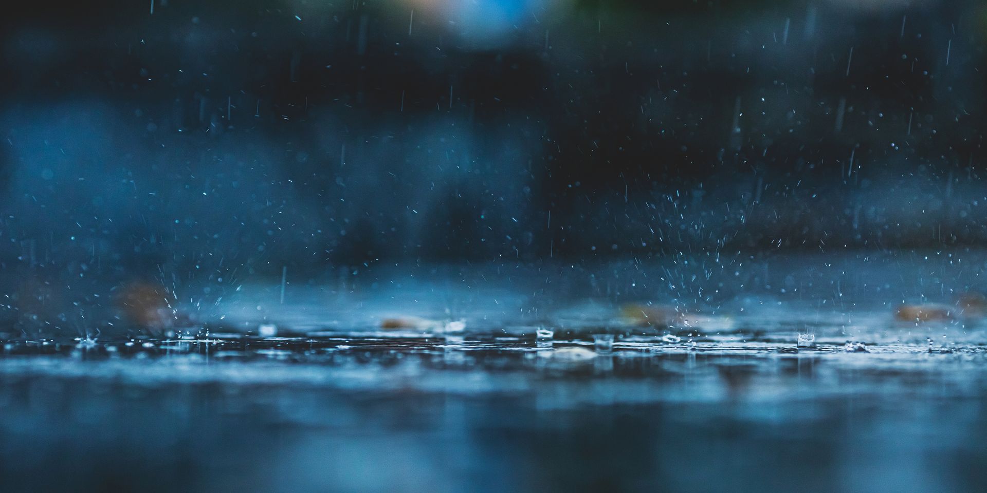 A close up of rain falling on a body of water.