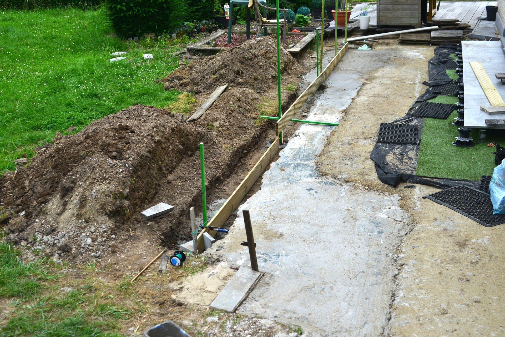 A concrete walkway is being built in a backyard
