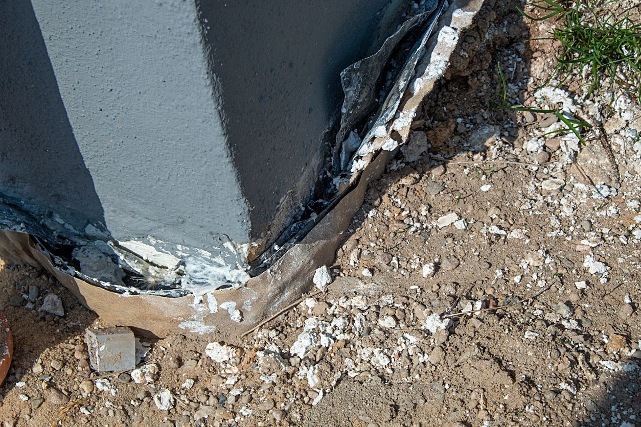 a concrete pillar is sitting on top of a pile of dirt .